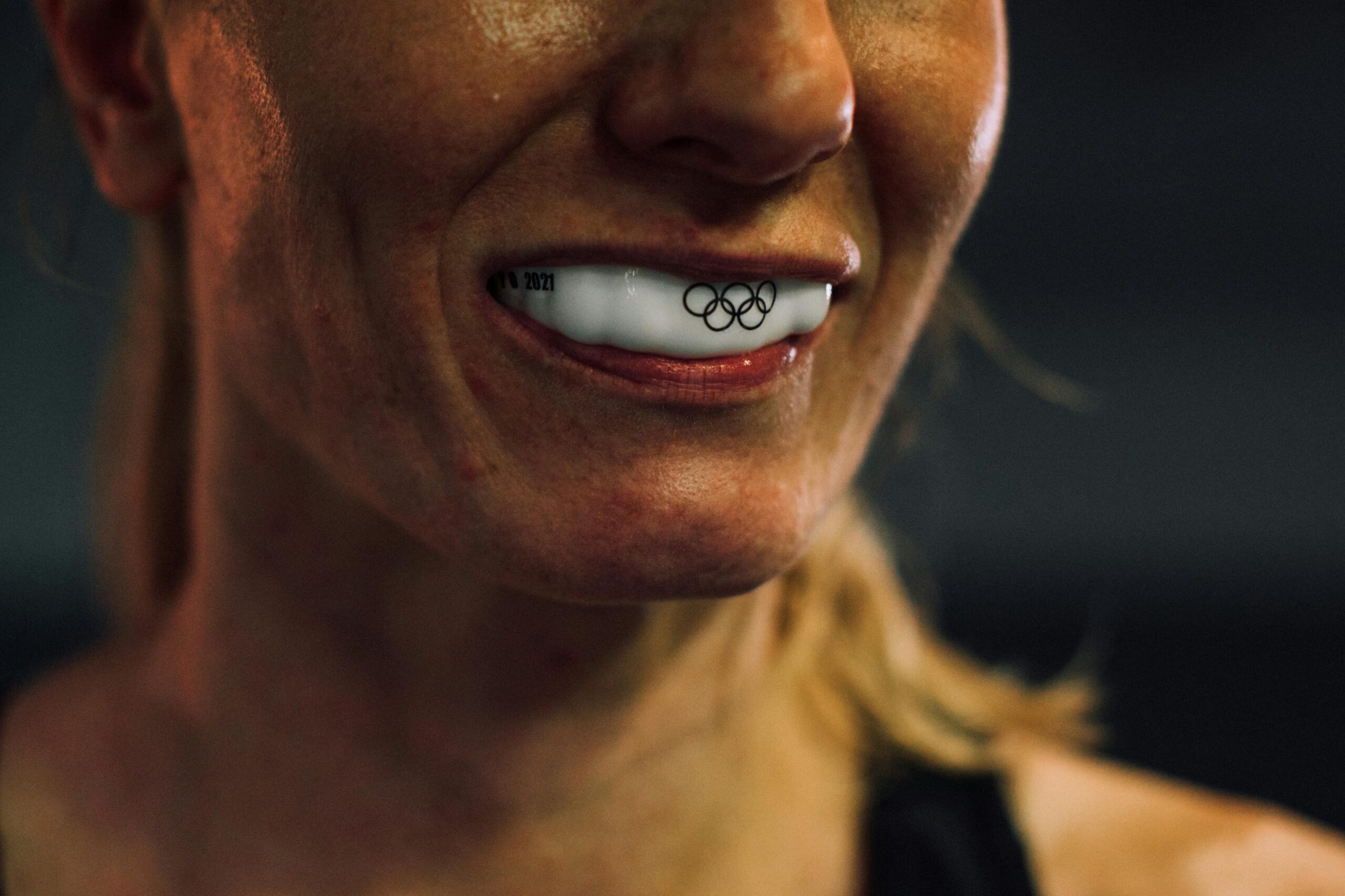 Close-up shot showcasing an athlete's mouthguard with Olympic rings engraving.