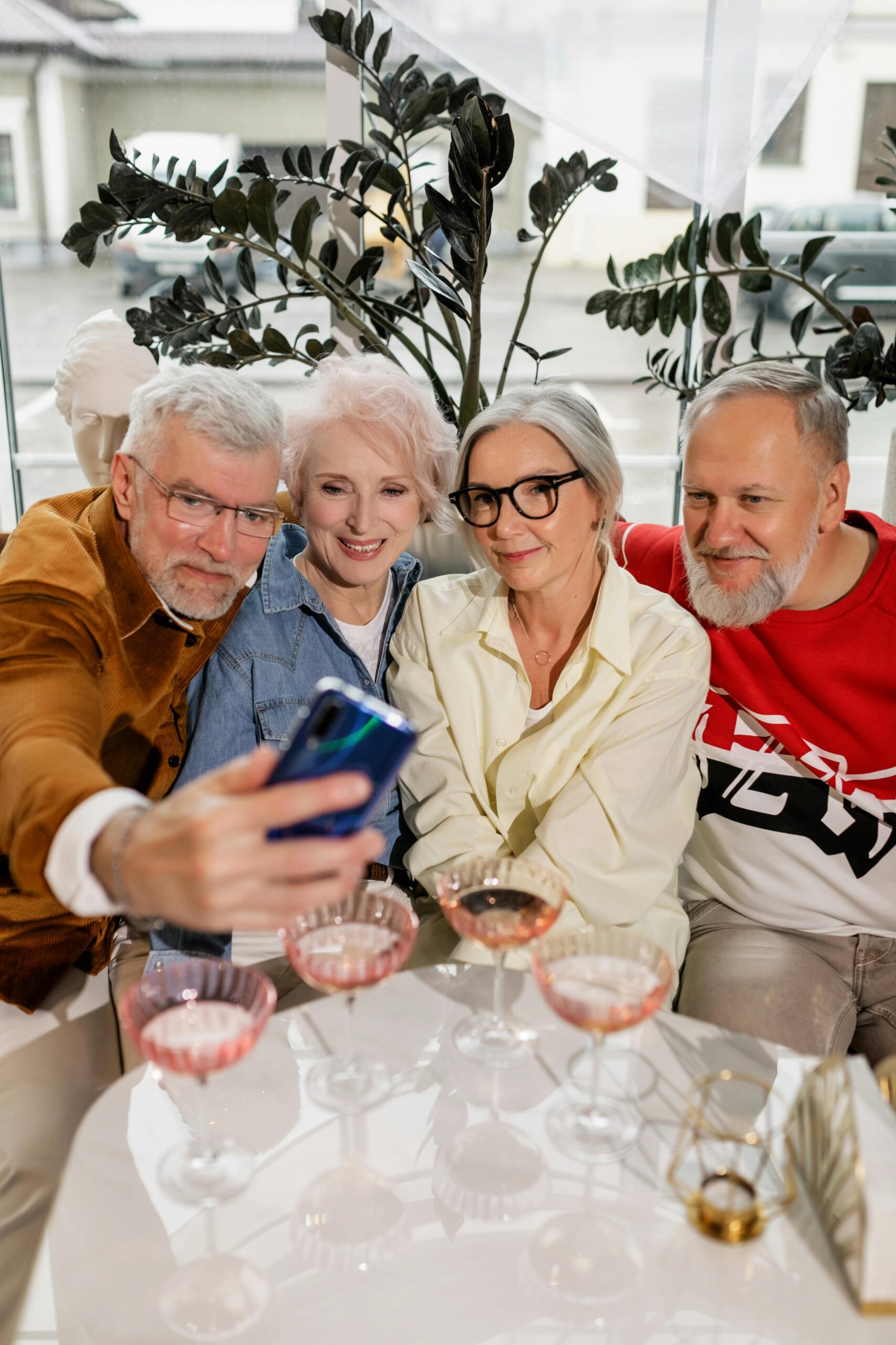 Senior friends share a joyful moment taking a selfie together, indoors.